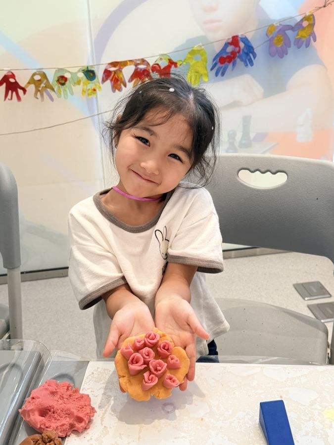 A girl showing a clay flower she made