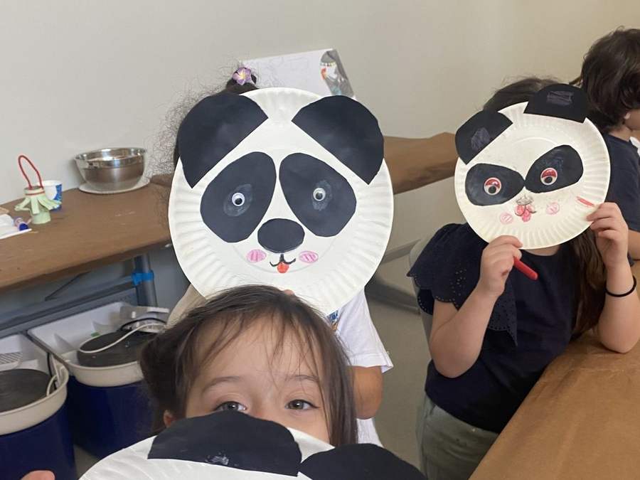 Children with panda masks they made at camp