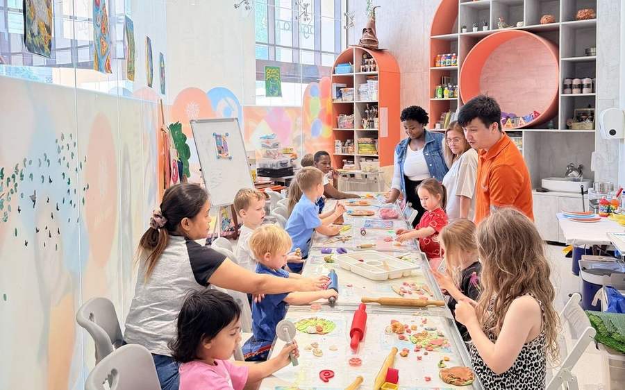 Children and teachers at the long tables in the TAKA TAKA club