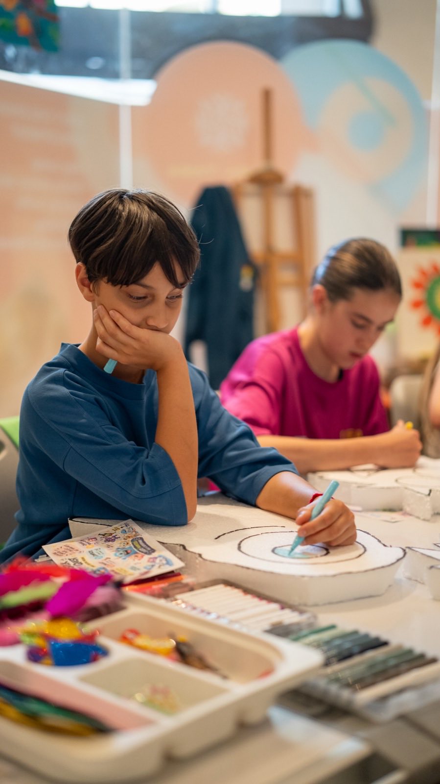 A boy colouring his monster at the art table
