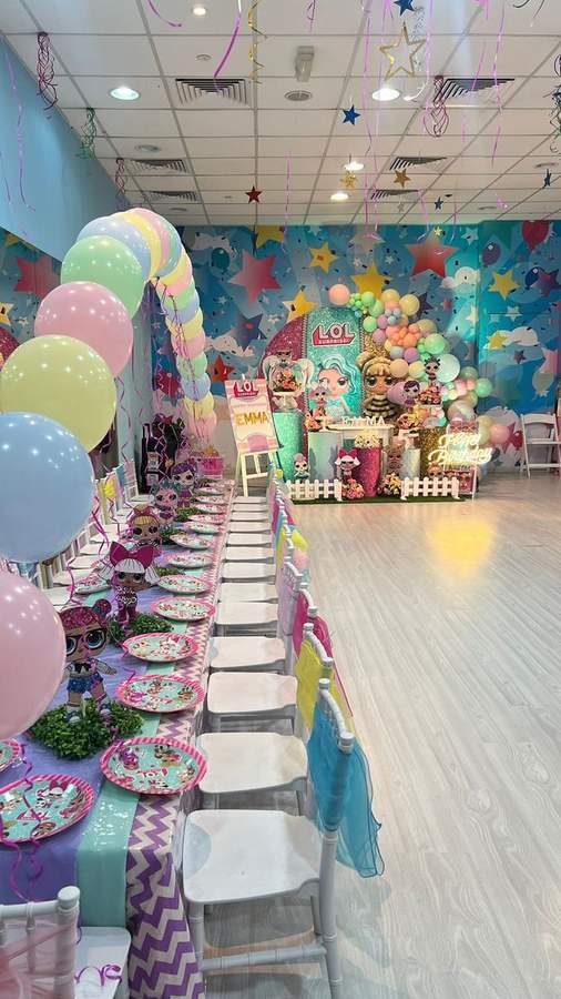 Long party table with a themed balloon wall