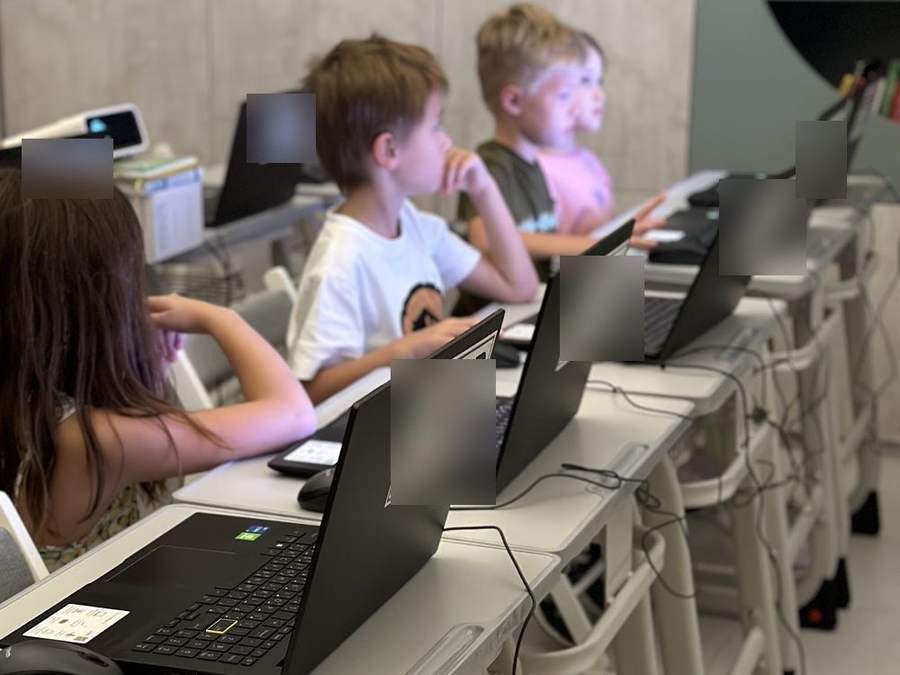 Children at laptops in a coding class