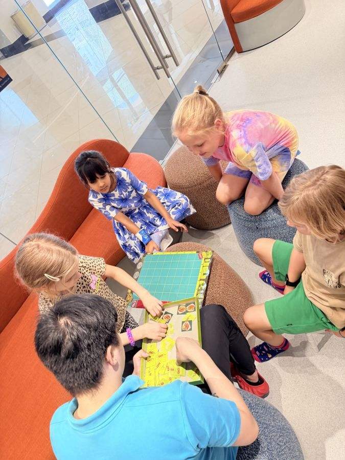 A teacher reading with children on the orange sofas